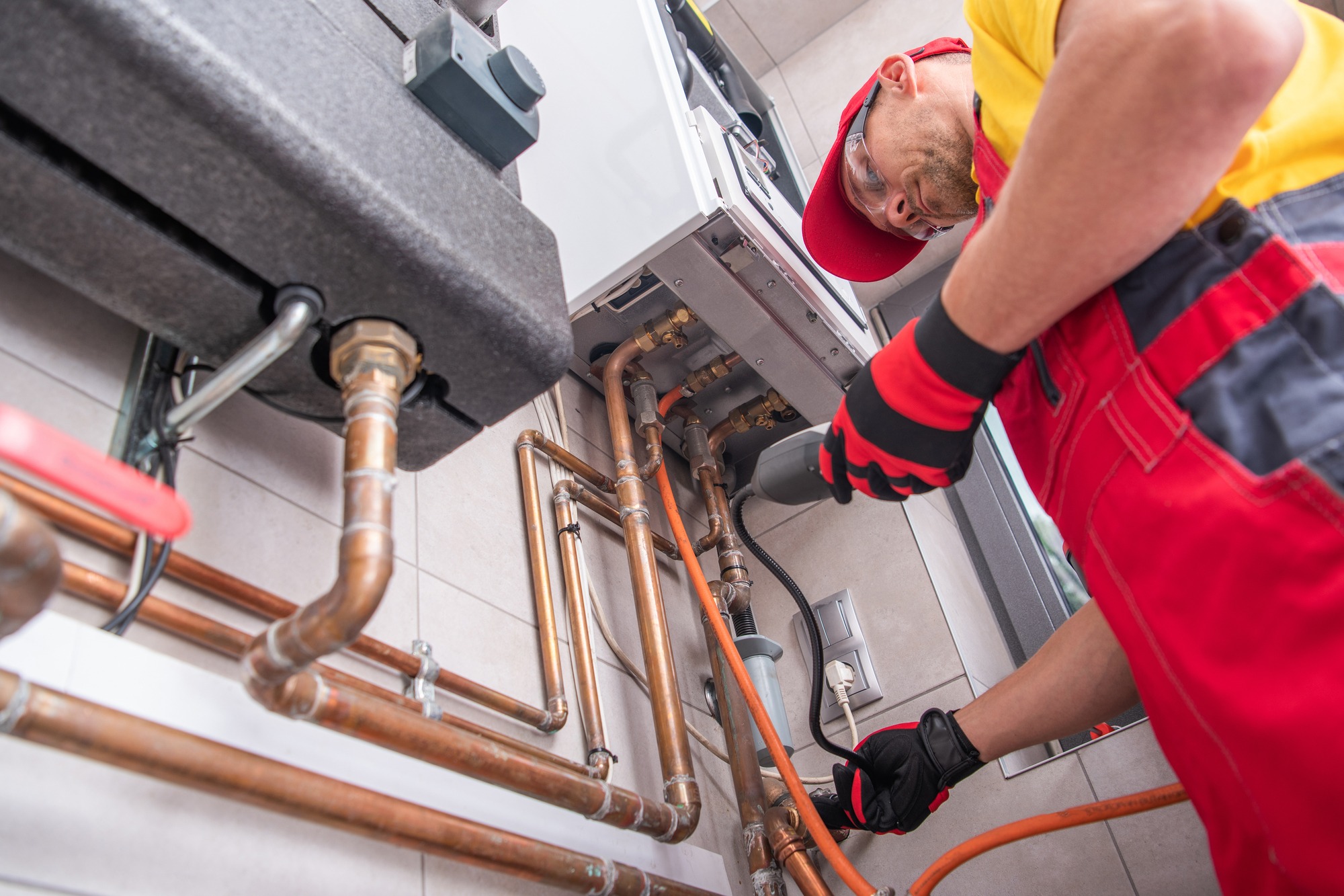 Professional Gas Heating Technician with Natural Gas Detector Device in His Hands Looking For Potential Leaks Inside the Heating Furnace System